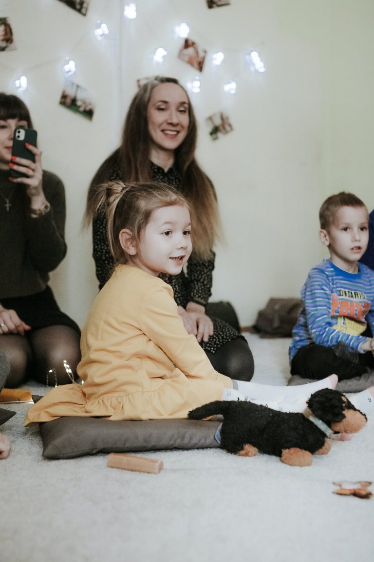 Children and Moms Sitting on Floor in Kindergarten