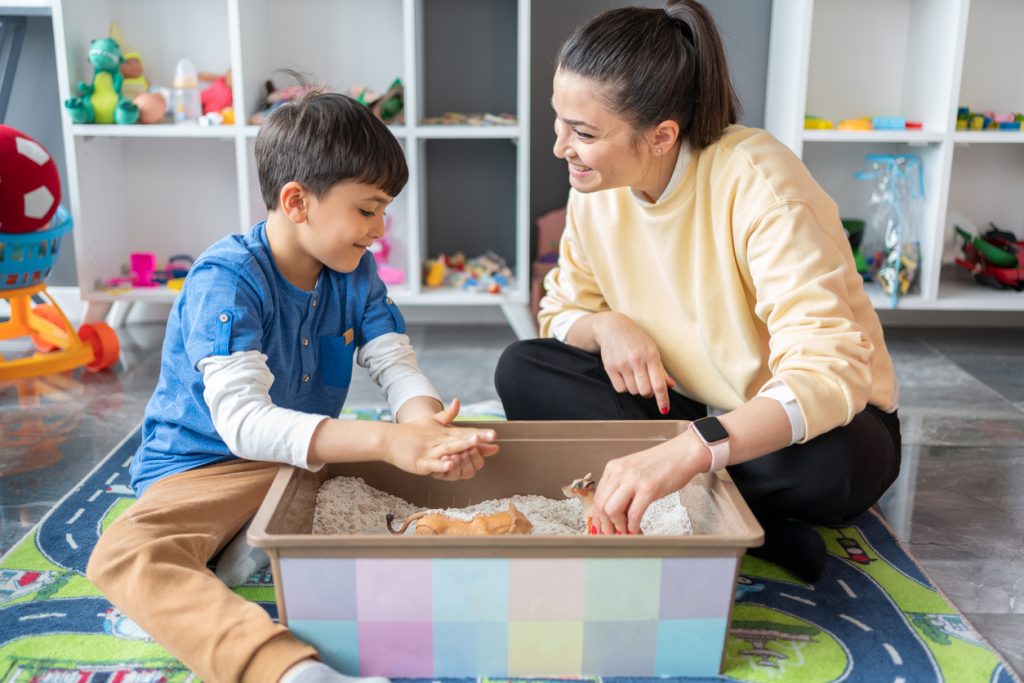 A Professional Child Psychologist Doing Sand Therapy With Little Boy
