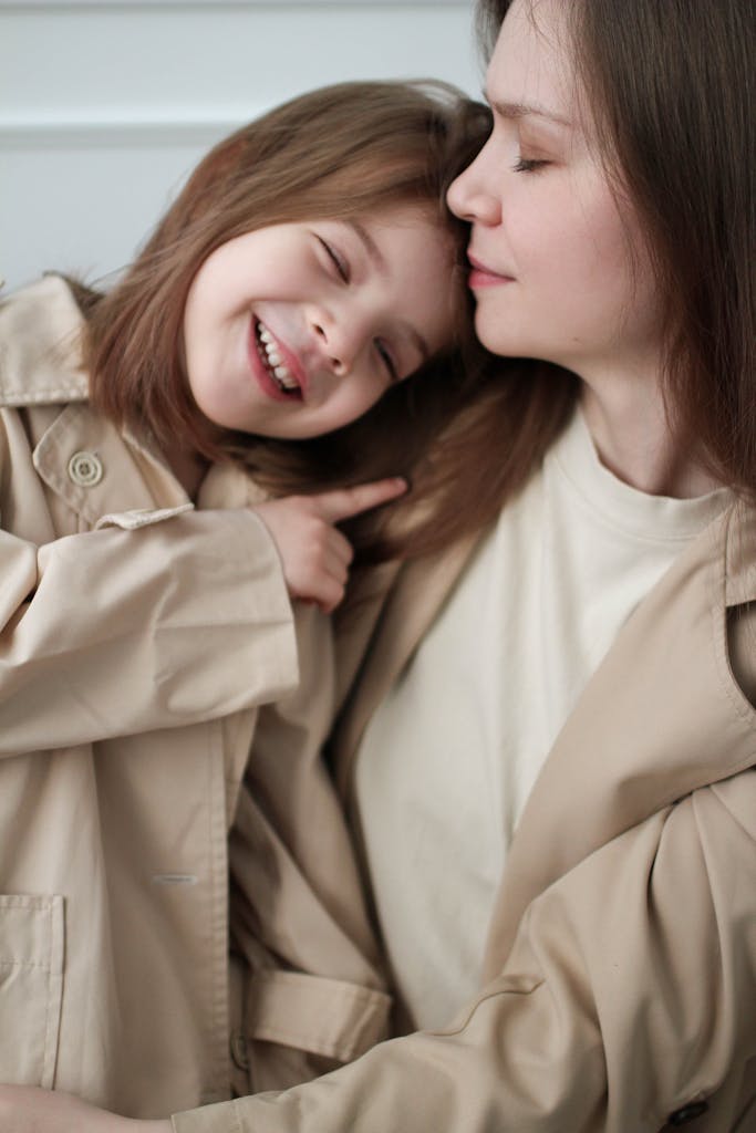 A loving and playful bond captured between a smiling mother and her daughter indoors.
